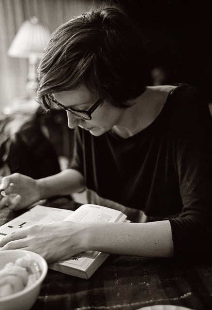 Black and white image of Katie Berta reading a book.